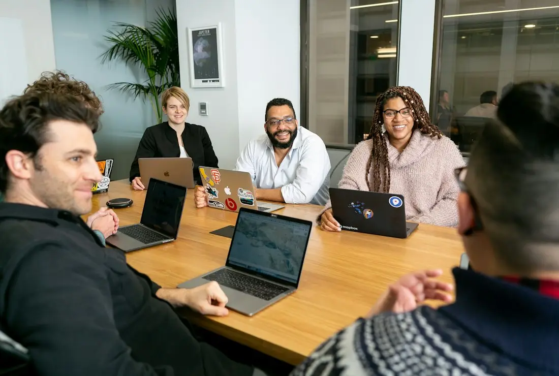 Colleagues with laptops in a board meeting